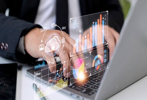 Business professional analyzing digital data on a laptop, featuring graphs and charts representing online reputation management and growth metrics for contractors in HVAC, plumbing, and electrical industries.